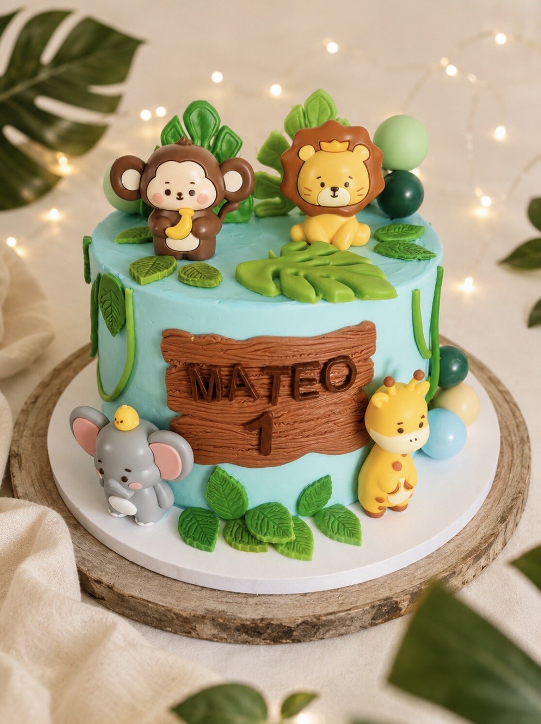 Gâteau de premier anniversaire sur le thème de la jungle, décoré d’un lion, d’un singe, d’un éléphant et d’une girafe